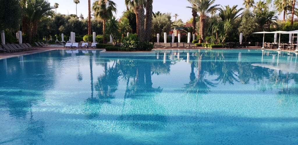Piscine extérieure d'un hôtel à Marrakech entourée de palmiers