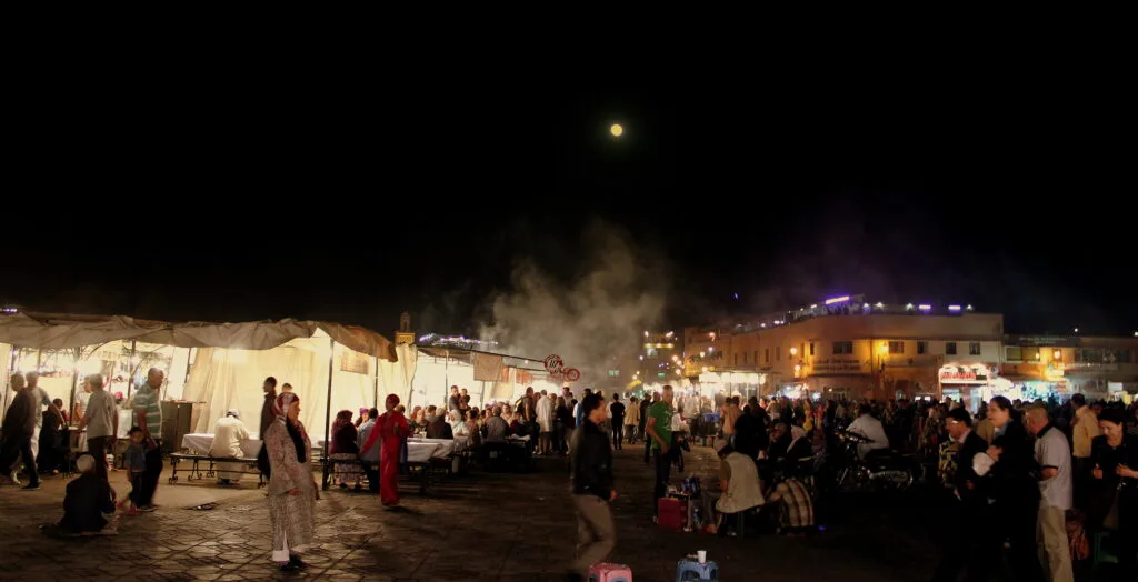 La place Jemaa el-Fna animée la nuit sous la pleine lune