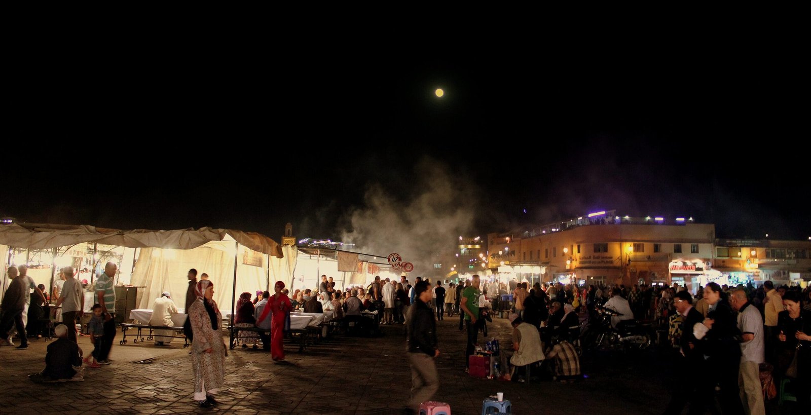 La place Jemaa el-Fna animée la nuit sous la pleine lune