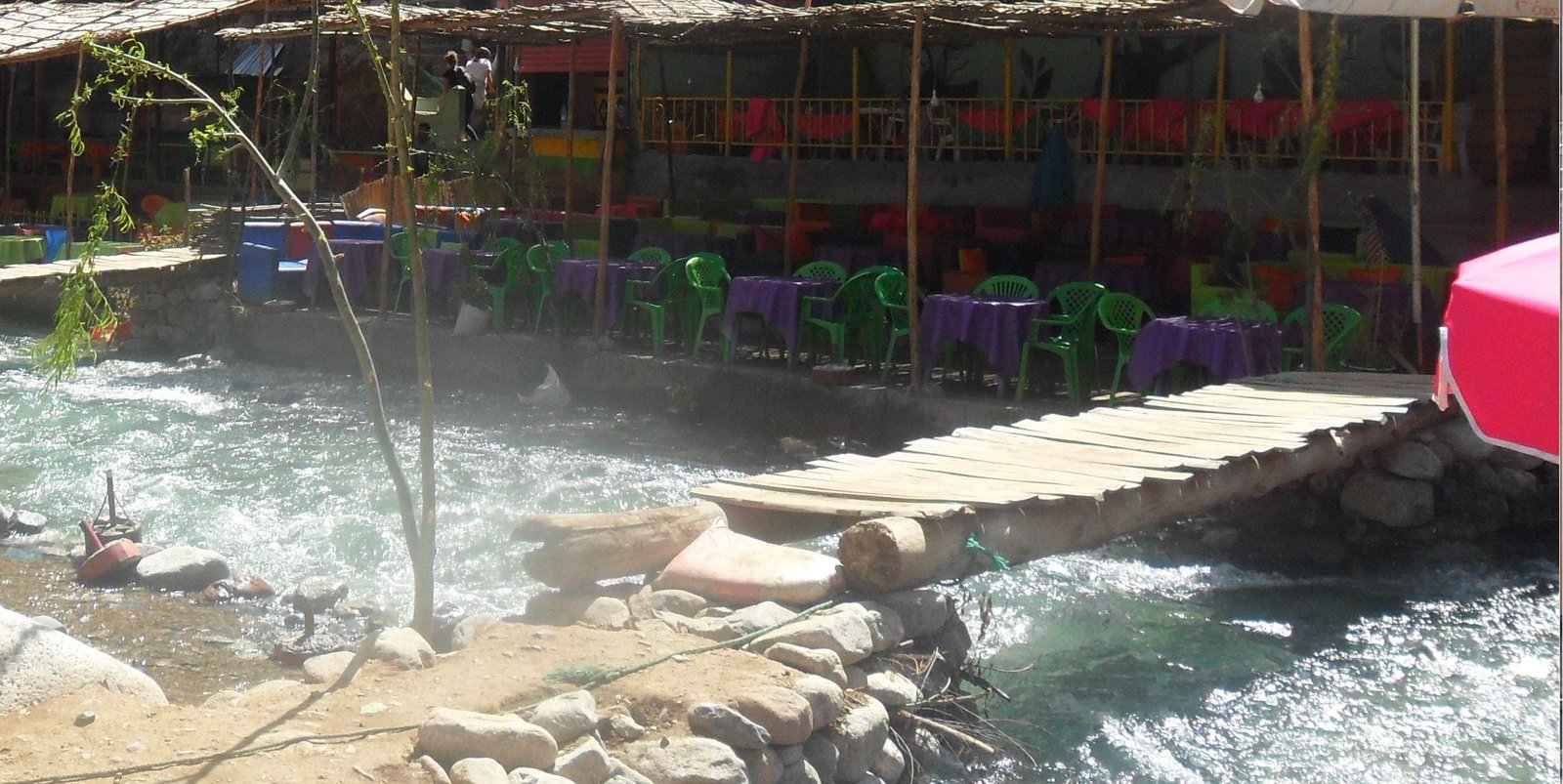 Pasarela de madera sobre el río y cafés a la orilla del agua en Setti Fatma