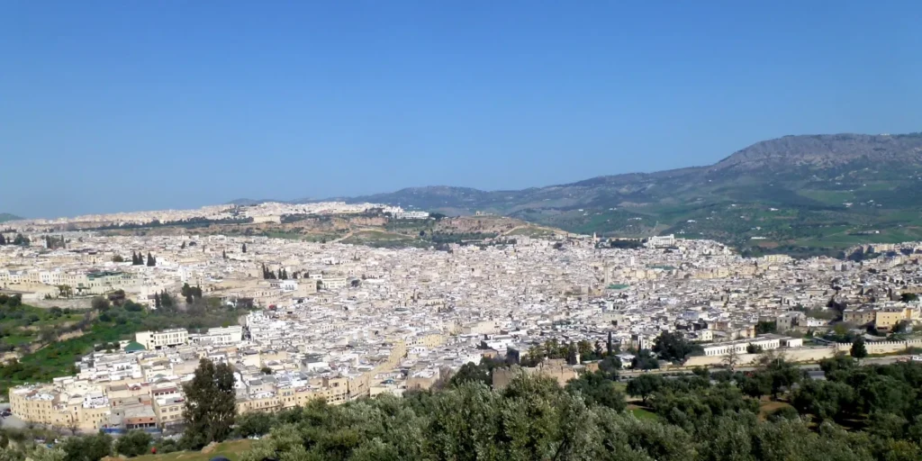 Vue panoramique de la médina de Fès depuis le Borj Sud, toits couleur sable et montagne du Zalagh au fond