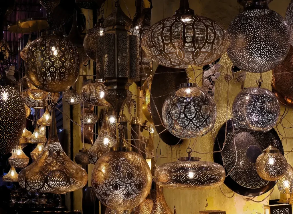 Rangées de lanternes en métal ajouré suspendues au-dessus d'une ruelle du souk Haddadine, dans la médina de Marrakech