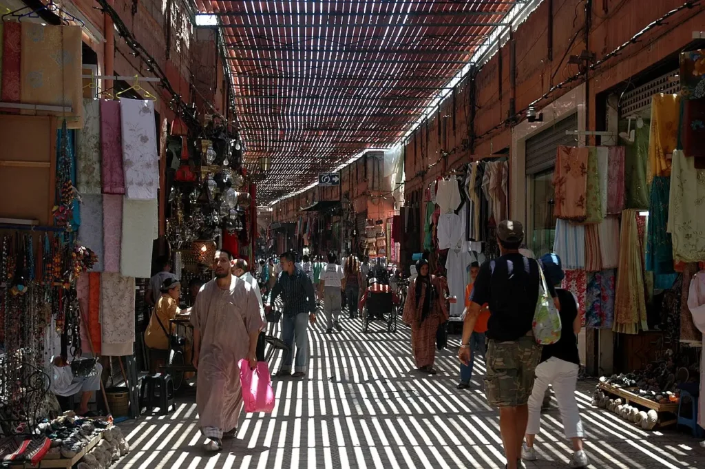 Vicolo coperto del souk Semmarine a Marrakech, strisce di luce che attraversano la copertura a graticcio sopra le botteghe